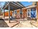 Inviting brick patio with a stylish pergola, cozy seating, and a welcoming entrance to the home at 1835 S Poplar St, Denver, CO 80224