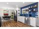 Modern kitchen with stainless steel appliances, blue tiled backsplash, and cozy dining area at 1835 S Poplar St, Denver, CO 80224