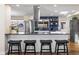Modern kitchen featuring a breakfast bar, stainless steel appliances, and attractive blue backsplash at 1835 S Poplar St, Denver, CO 80224