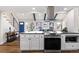 Open concept kitchen with stainless steel appliances, white cabinets, and an island with seating at 1835 S Poplar St, Denver, CO 80224