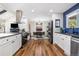 Bright, open kitchen with stainless steel appliances, a cozy dining area, and views to the living space at 1835 S Poplar St, Denver, CO 80224