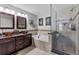 Bright bathroom with dual sinks, a soaking tub, and a glass-enclosed shower at 19935 E Stanford Dr, Centennial, CO 80015