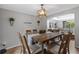Bright dining room featuring a wooden table set, a decorative chandelier and wall decor, perfect for Gathering meals and gatherings at 19935 E Stanford Dr, Centennial, CO 80015