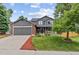 Charming two-story home featuring a well-manicured lawn, gray siding, brick accents and an attached two-car garage at 19935 E Stanford Dr, Centennial, CO 80015