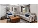 Comfortable living room featuring a large sectional sofa, a decorative coffee table, shelving and a large window at 19935 E Stanford Dr, Centennial, CO 80015