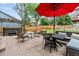 Inviting outdoor patio area featuring comfortable seating, a hot tub, and a vibrant red umbrella for shade at 19935 E Stanford Dr, Centennial, CO 80015
