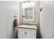 Well-lit half bathroom featuring a vanity with a sink and a decorative mirror at 1832 S Quintero Way, Aurora, CO 80017