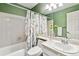 Bathroom featuring tub-shower combo with bright green paint and flower-themed shower curtain and vanity at 1832 S Quintero Way, Aurora, CO 80017