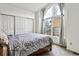 Bedroom featuring large window and natural light, a bed, and closet with sliding doors at 1832 S Quintero Way, Aurora, CO 80017