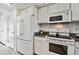 Bright kitchen featuring granite countertops, white cabinets, and stainless steel appliances at 1832 S Quintero Way, Aurora, CO 80017