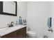 Elegant half-bathroom featuring a modern sink, dark wood vanity, decorative mirror, and stylish decor at 4750 S Dudley St # 21, Littleton, CO 80123