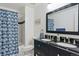 Bathroom featuring double vanity, shower with blue curtain, and tiled floors offering style and functionality at 4750 S Dudley St # 21, Littleton, CO 80123