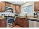 Modern kitchen featuring stainless steel appliances, granite countertops, wood cabinets, and hardwood floors at 4750 S Dudley St # 21, Littleton, CO 80123
