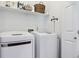 Functional laundry room featuring a modern washer and dryer, a storage shelf, and white walls at 4750 S Dudley St # 21, Littleton, CO 80123