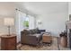 Comfortable living room featuring a large window, plush sofa, decorative rug, and a view of the backyard at 4750 S Dudley St # 21, Littleton, CO 80123