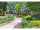 Scenic community walking path lined with colorful flowerbeds and mature trees at 4750 S Dudley St # 21, Littleton, CO 80123