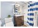 Well-lit bathroom features a vanity with dark wood cabinets and a shower with blue striped curtain at 75 N Emerson St # 206, Denver, CO 80218