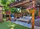 Charming backyard patio with a pergola, comfortable seating, lush greenery, and hanging floral baskets at 1051 S York St, Denver, CO 80209