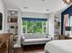 Bright bedroom featuring built-in shelving, a cozy seating area, and a large window with natural light at 1051 S York St, Denver, CO 80209