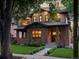 Charming two-story brick home featuring a well-maintained lawn, landscaped flower beds and a covered porch at 1051 S York St, Denver, CO 80209