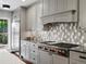 Well-lit kitchen with stainless steel appliances, custom cabinets, and decorative backsplash at 1051 S York St, Denver, CO 80209