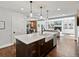 Bright, modern kitchen island with a farmhouse sink and stylish pendant lighting open to the living area and dining room at 1051 S York St, Denver, CO 80209