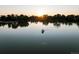 Peaceful lake view with a boat on the water and the sun setting in the background at 1051 S York St, Denver, CO 80209