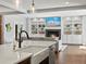 Open-concept living room featuring a fireplace, built-in shelving, and a modern kitchen island with stone countertops at 1051 S York St, Denver, CO 80209