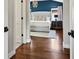 Spacious main bedroom with hardwood floors, a tufted headboard, and calming blue accent wall at 1051 S York St, Denver, CO 80209