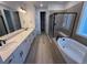 Modern bathroom featuring a double vanity, a soaking tub and a glass-enclosed shower at 1121 Joseph Pl, Erie, CO 80026