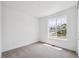 Bright bedroom featuring neutral carpet, white walls, baseboards, and a large window with neighborhood views at 1121 Joseph Pl, Erie, CO 80026