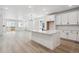 Open kitchen featuring a large island with counter seating, white cabinets, and wood look floors at 1121 Joseph Pl, Erie, CO 80026