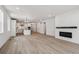 The open living space flows into the kitchen and features a modern fireplace and wood-look floors at 1121 Joseph Pl, Erie, CO 80026