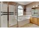 Bathroom with glass shower, soaking tub, and neutral tile at 16350 Timber Cove St, Hudson, CO 80642