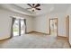 Expansive bedroom with plush carpet, ceiling fan, and patio access at 16350 Timber Cove St, Hudson, CO 80642