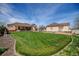 Spacious backyard with manicured lawn connecting the main house and detached garage at 16350 Timber Cove St, Hudson, CO 80642