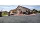 Well-maintained exterior with stone accents, a large driveway, and beautiful landscaping at 16350 Timber Cove St, Hudson, CO 80642