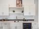 Basement bar with white cabinets, quartz countertops, and a wine cooler at 3897 Piney Grove St, Evergreen, CO 80439