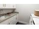Modern laundry room with white cabinets, quartz countertops, and a utility sink at 3897 Piney Grove St, Evergreen, CO 80439