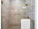 Walk-in shower with marble tile and gold accents at 3897 Piney Grove St, Evergreen, CO 80439