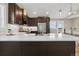 Modern kitchen with a large island, stainless steel appliances, pendant lights and beautiful countertop at 11840 Elkhorn Dr, Franktown, CO 80116