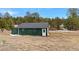 Exterior shot of a green outbuilding with white trim and a single door at 11840 Elkhorn Dr, Franktown, CO 80116