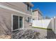 Backyard patio area featuring a privacy fence, sliding glass door, and well-maintained lawn at 5538 Espana Ct, Denver, CO 80249