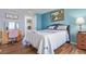 A bedroom with hardwood flooring, a washing machine, desk with mirror and cozy bed with a flower-themed white comforter at 5538 Espana Ct, Denver, CO 80249