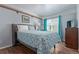 A bedroom with grey walls and hardwood flooring, a window, and a bed with grey headboard and blue patterned comforter at 5538 Espana Ct, Denver, CO 80249
