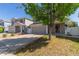 Traditional home featuring a manicured lawn, mature trees, and attached two-car garage at 5538 Espana Ct, Denver, CO 80249
