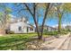 View of the home's exterior with a mature tree and landscaped yard and sidewalk at 4120 S Lincoln S St, Englewood, CO 80113