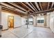 Unfinished basement with exposed wood beams, concrete floors, and natural light from window wells at 14434 W 88Th Dr # B, Arvada, CO 80005