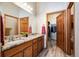 Well-lit bathroom with dual sinks, granite countertops and a wood-look tile floor at 14434 W 88Th Dr # B, Arvada, CO 80005