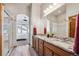 Bright bathroom featuring double sinks, a large mirror, and an archway to the bedroom at 14434 W 88Th Dr # B, Arvada, CO 80005